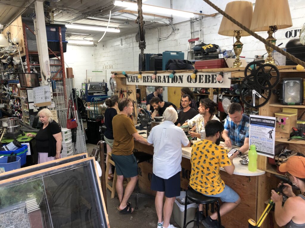 A group of 12 people is working in a repair workshop at La Patente in Québec City.